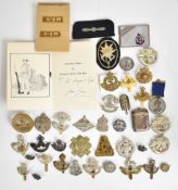 Collection of cap badges and shoulder titles to include Royal Army Medical Corps Volunteer in