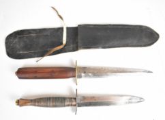 Two Fairbairn-Sykes style commando fighting knives, one with 13.5cm double edged blade, crossguard