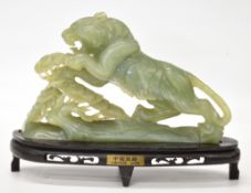 Chinese carved jadeite or similar leaping lion figure, on stand bearing 'Chinese Jade' plaque,