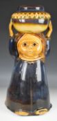 Glazed stoneware figural stick or umbrella stand in the form of a girl carrying a pot on her head,