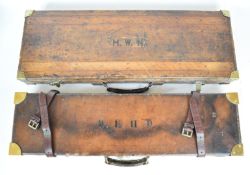 Two leather and brass bound shotgun carry cases one double example with fitted interior for two guns