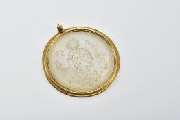 A 19thC yellow metal pendant set with an engraved mother of pearl plaque depicting a naked man
