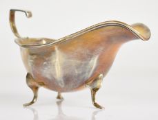 George V hallmarked silver sauce boat of octagonal form and raised on three feet, Birmingham 1921,