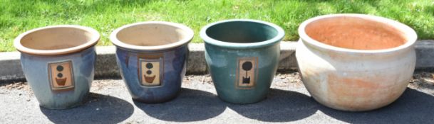 Set of three garden jardinières with flower pot motifs and a large terracotta planter, largest