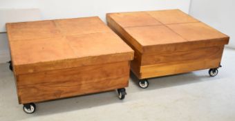 Two leather clad hardwood storage trunks on wheels, W96 x D96 x H47cm