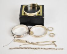 A collection of silver jewellery including three bangles, two rings, watch chain made into a