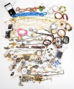A collection of costume jewellery including rolled gold bangle, vintage brooches, a silver brooch,