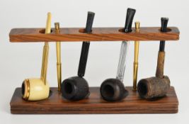 Four smoking pipes and rack, pipes include Jima, Colibri and Falcon