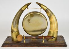 19th / 20thC gong with horn mounts, on wooden base, W43.5 x H30cm