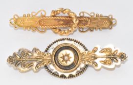 Two Victorian 15ct gold brooches, one set with a seed pearl and a locket compartment to the back,