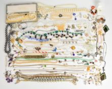 A collection of costume jewellery including pearl earrings, tiger's eye earrings, vintage rolled