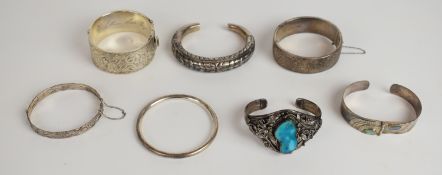 Seven silver bangles including two hallmarked with engraved decoration, one set with abalone, one