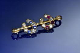c1900 yellow metal brooch in the form of two horseshoes set with old cut diamonds, rubies and