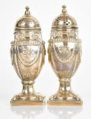 Pair of Victorian or Edward VII hallmarked silver peppers of neoclassical urn design with foliate