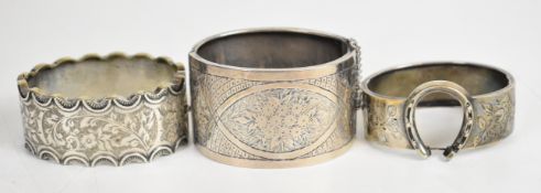 Two hallmarked silver bangles, one with horseshoe decoration and the other with engraved floral