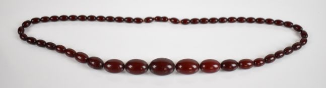 A cherry amber necklace made up of fifty one graduated beads, largest bead 19 x 26mm, smallest