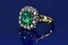 An 18ct gold ring set with cushion cut emerald of approximately 2ct surrounded by fourteen round