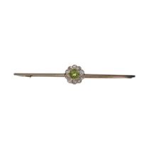 AN EARLY 20TH CENTURY 15CT GOLD, DIAMOND AND PERIDOT BAR BROOCH Set with a round cut peridot edged