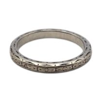 AN EARLY 20TH CENTURY WHITE METAL WEDDING BAND Having Celtic decoration. (tests as gold, approx 4.