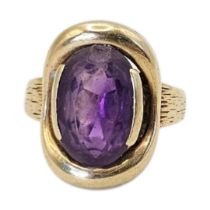 A VINTAGE 9CT GOLD AND AMETHYST GENT'S SIGNET RING Oval cut stone with engraved bark decoration to