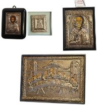 A COLLECTION OF FOUR SILVER CLAD RELIGIOUS ICONS The rectangular panel depicting Saint Nicholas in