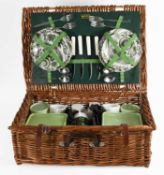 A Braxton Wicker Picnic Set, for four people, with green and white cups, saucers and side plates