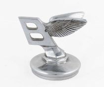 A Bentley Winged Chrome Car Mascot, mounted on a circular radiator cap, height 9cm Some pitting to