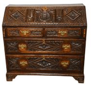 An 18th Century Carved Oak Bureau, with lozenge and foliate all over design, 113cm by 52cm by
