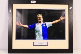 A signed photographic image of Tugay Kerimoglu in Blackbrun Rovers kit,