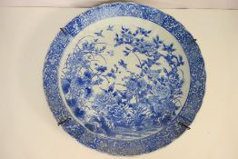 A large 19th century Japanese Arita blue and white charger decorated with birds amidst flowers,