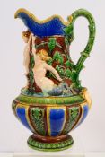 A Minton Vicorian Majolica ewer decorated in relief with a cherub flanked by a merman and mermaid,