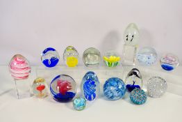 A collection of paperweights to include Langham Glass and other.