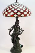 A large table lamp with figural stem and Tiffany style shade, approximately 80 cm (h).