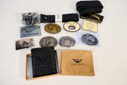 A collection of belt buckles, belts and a wallet.