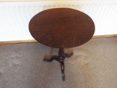 An antique oak tilt top occasional table, the column on a tripod base,