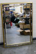 A large gilt framed, bevel edge wall mirror, approximately 73 cm x 104 cm.