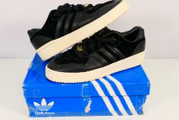 Adidas - A pair of Rivalry Low Velvet Pack trainers in black, UK size 9, contained in an Adidas box.