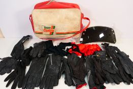 A vintage Team Castrol bag containing a quantity of motorcycle and similar gloves.