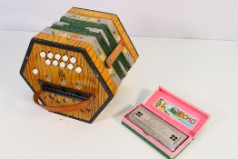 A vintage German concertina by BM and a boxed Hohner Echo Harp.