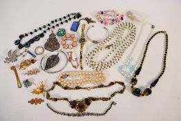 A collection of costume jewellery to include brooches, necklaces, bangles and other.