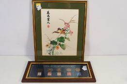 A framed Oriental silk embroidery depicting a bird amidst foliage, mounted and framed under glass,