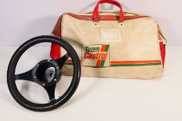 A vintage leather clad three spoke steering wheel contained in a Team Castrol bag.
