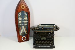 A vintage Underwood typewriter and a decorative display of knots in boat form display case.