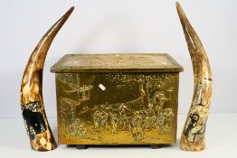 A brass clad coal box with embossed decoration and two cattle horns with hand painted decoration.
