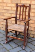 A child's vintage rocking chair with wicker seat.
