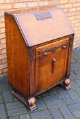 An oak bureau with carved decoration, th