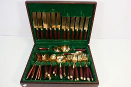 A canteen of cutlery, gilt metal with wooden handles.