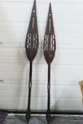 A pair of carved wood ceremonial paddle