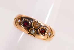 A 9ct rose gold ring set with garnet and split pearl, size O, approximately 2.8 grams.