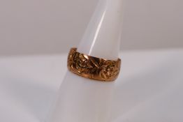 A rose metal band with engraved floral decoration, size O, approximately 3.